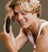 Smiling young man with blonde hair holding a Meridian branded nose and ear hair trimmer.