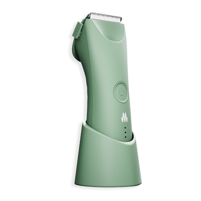 Cordless green electric hair clipper with adjustable blade, power button, and charging stand for grooming.